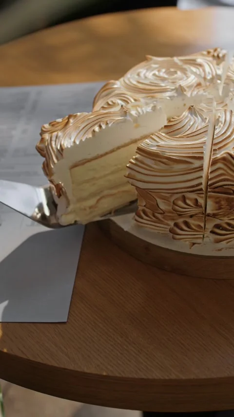 Slice of festive airy cake with white buttercream separates from a large cake Stock Footage 310500460