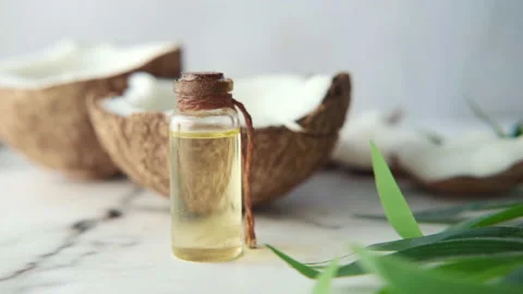 Slice of fresh coconut and bottle of oil on a table Stock Footage 152714904