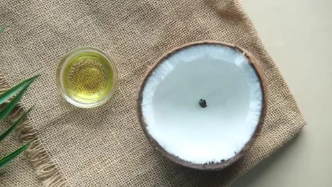 Slice of fresh coconut and bottle of oil on a table Stock Footage 182429292