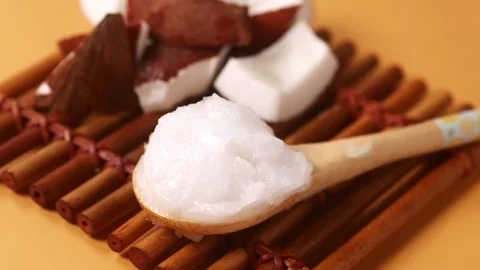 Slice of fresh coconut and bottle of oil on a table Stock Footage 274377759