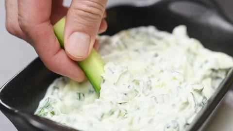 Slice of fresh cucumber is dipping into green onion dip, slow motion. Vídeos de archivo 151047260