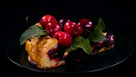 Slice of fresh homemade pie with cherries and decorated with mint leaves. 4K Stock Footage 78069343