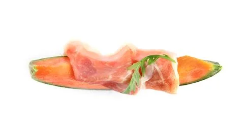 Slice of fresh melon with prosciutto and arugula on white background, top vie Stock Photos