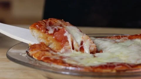 A slice of fresh pizza is raised above plate of pizza, slice of pizza, wooden Stock Footage 225886363