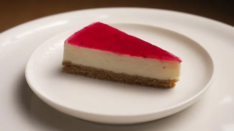 Slice of fresh raspberry cheesecake with jelly topping Stock Footage 335375209