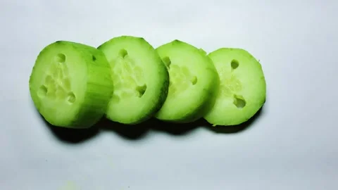 Slice of fresh raw Cucumber in studio light shot on white background 動画素材 297681998