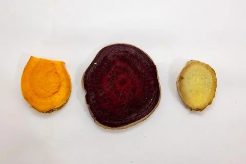 Slice of fresh raw turmeric, beetroot and ginger in studio on blurred white.. Stock Photos
