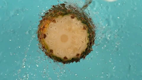 Slice of fresh ripe pineapple rotates under stream of clear water slow moti.. Stock Footage 327578367