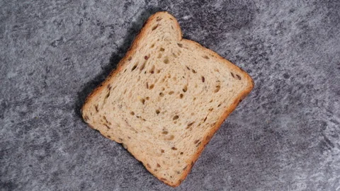Slice of fresh toast bread with seeds on dark background. Stock Footage 260243090