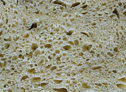 Slice of freshly baked gray rye bread close-up. Bread texture backdrop Stock Photos