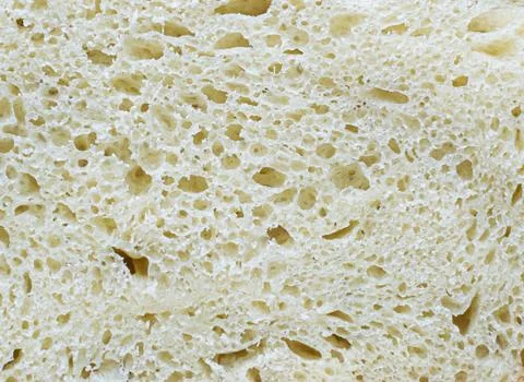 Slice of freshly baked white bread close-up. Bread texture backdrop Stock Photos