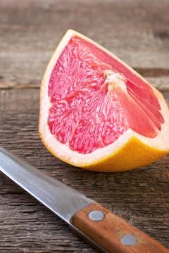 Slice of grapefruit and knife Stock Photos