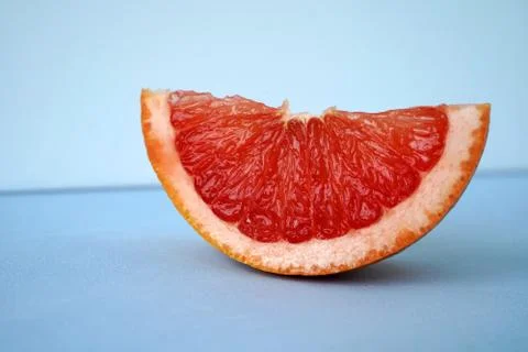 Slice of grapefruit on blue background Stock Photos