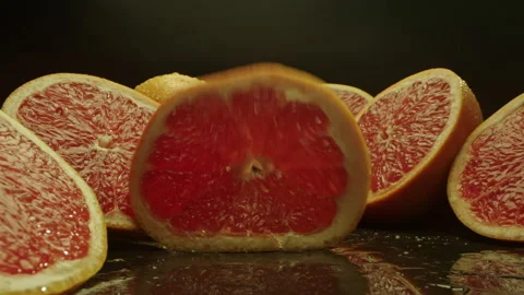 Slice of grapefruit dropped onto grapefruit halves Stock Footage 154128289