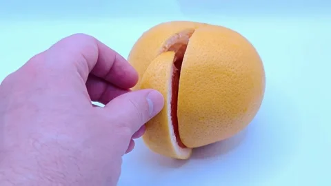 A slice of grapefruit in hands Stock Footage 331746428