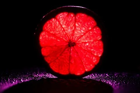 Slice grapefruit neon red backlit Stock Photos