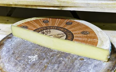 Slice of the Gruyere de Comte Aging Cheese on wooden shelves Stock Photos