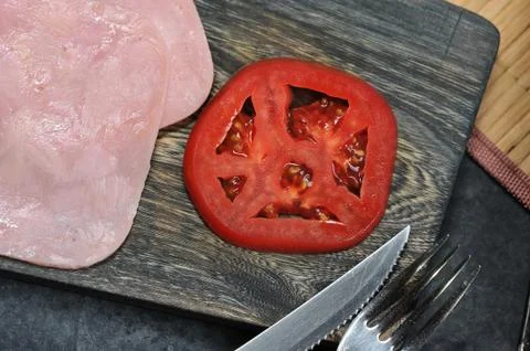 A slice of ham and a slice of tomato o Foto stock
