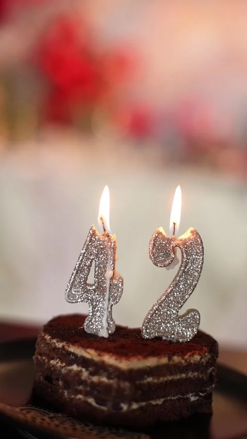 A slice of heart-shaped cake with lit candles Stock Footage 336679760