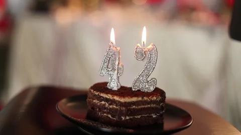 A slice of heart-shaped cake with lit candles Stock Footage 336679765