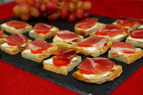 A slice of jamon on bread with fresh cheese and cherry tomatoes, a traditiona Stock Photos