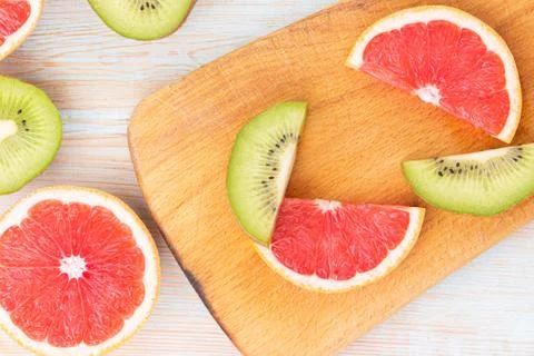 Slice kiwi, grapefruit pattern on wooden background. copy space. Stock Photos