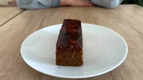 Slice of layered caramel cake with glossy glaze on white plate  Stock Footage 342438099