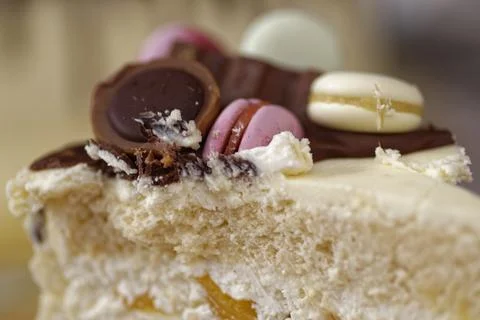 Slice of Layered Celebration Cake with Fruit Filling and Macaron Topping Stock Photos