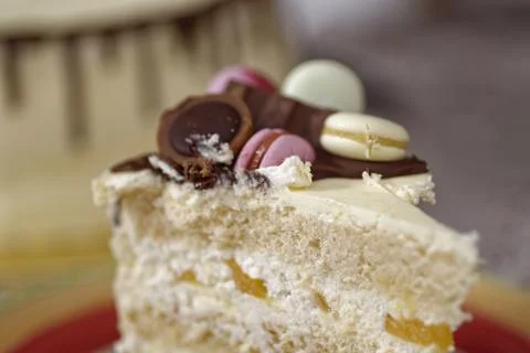 Slice of Layered Celebration Cake with Fruit Filling and Macaron Topping Stock Photos