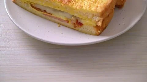 Slice of layered ham and cheese sandwich on white plate Stock Photos