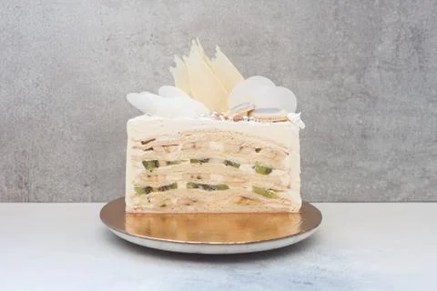 Slice of layered vanilla sponge cake with fresh bananas and kiwi inside. Stock Photos