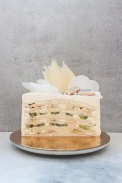 Slice of layered vanilla sponge cake with fresh bananas and kiwi inside. Stock Photos