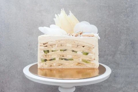 Slice of layered vanilla sponge cake with fresh bananas and kiwi inside. Stock Photos