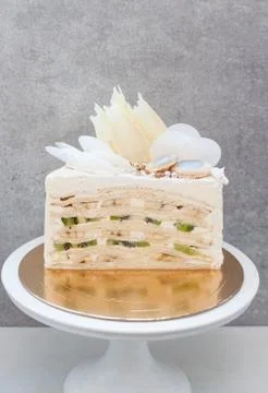 Slice of layered vanilla sponge cake with fresh bananas and kiwi inside. 스톡 사진