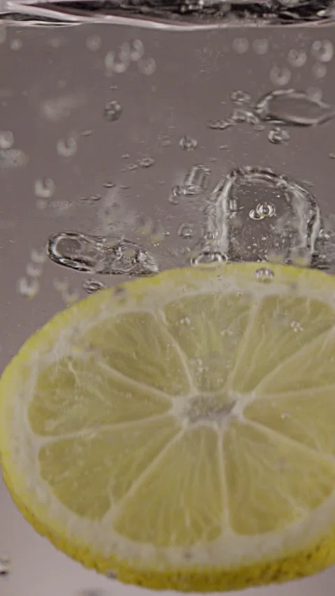 A slice of lemon falls into soda water, on a white background 스톡 동영상 237706147