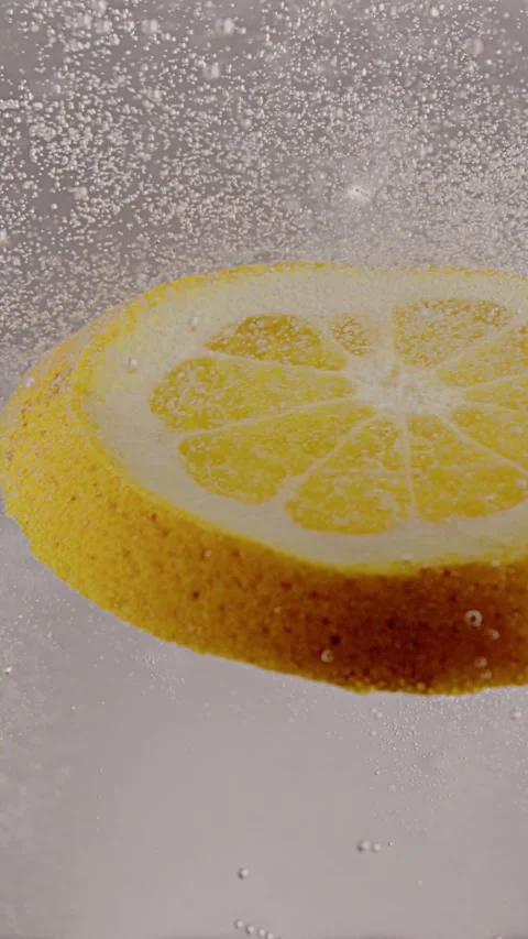 A slice of lemon falls into soda water, on a white background 스톡 동영상 237706153