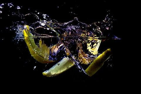 A slice of lemon falls into the water Stock Photos