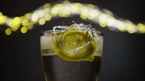 Slice of lemon,lime dropped into glass full of water and ice cubes Stock Footage 128431540