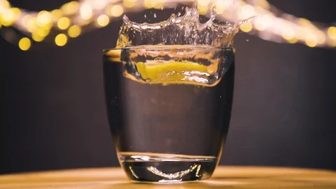 Slice of lemon,lime dropped into glass full of tonic Stock Footage 128698699