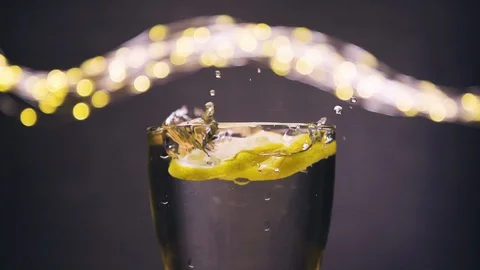 Slice of lemon,lime dropped into glass full of soda Stock Footage 128698843