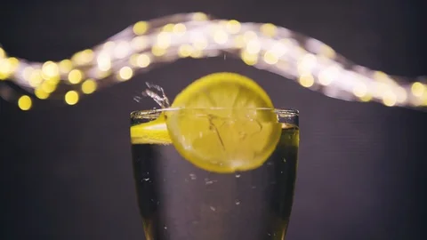 Slice of lemon,lime dropped into glass full of soda Stock Footage 128699050