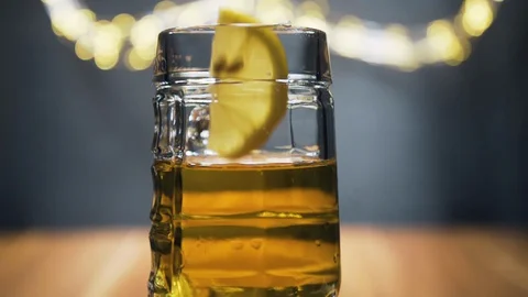 Slice of lemon,lime dropped into glass full of beer Stock Footage 128702063