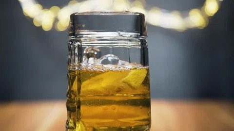 Slice of lemon,lime dropped into glass full of beer Stock Footage 128702187