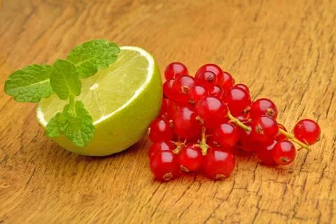 Slice of lime and red currant Stock Photos