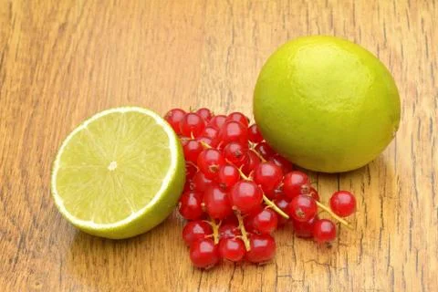 Slice of lime and red currant Stock Photos