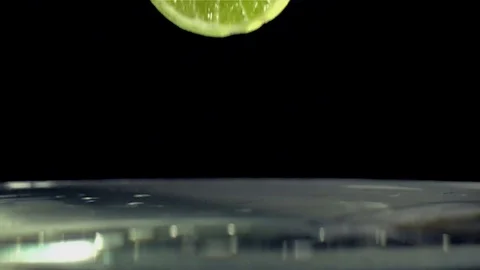 Slice of Lime splashing into water Stock Footage 70092252