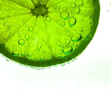 Slice of lime with water drops Stock Photos