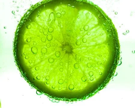 Slice of lime with water drops Stock Photos