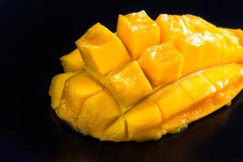 A slice of mango on a black background Stock Photos