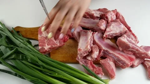 Slice the meat on a white table.Pork on the bone.On a wooden Board,closeup. 스톡 동영상 133124881